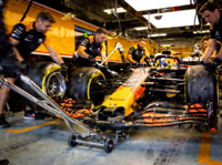 F1赛车在维修站内进行快速换胎，技师团队紧密协作