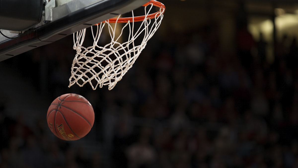NBA季后赛赛场全景，球员在聚光灯下激烈对抗，观众席座无虚席